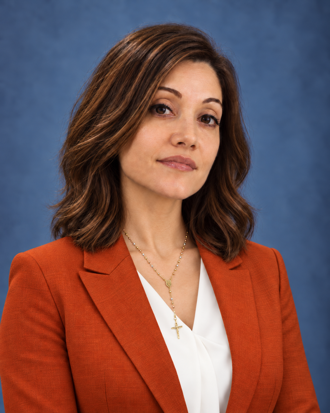 Cirena in an orange blazer with a subtle smile.